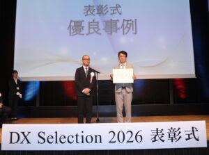DXセレクション2026受賞企業として優良事例に選定され、表彰状を持つ旭光電機株式会社代表取締役社長の和田貴志