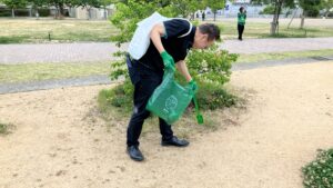 緑縁座の軍手・ごみ袋、貸出掃除用具を使用し、湊川公園内のごみ拾いをする社員